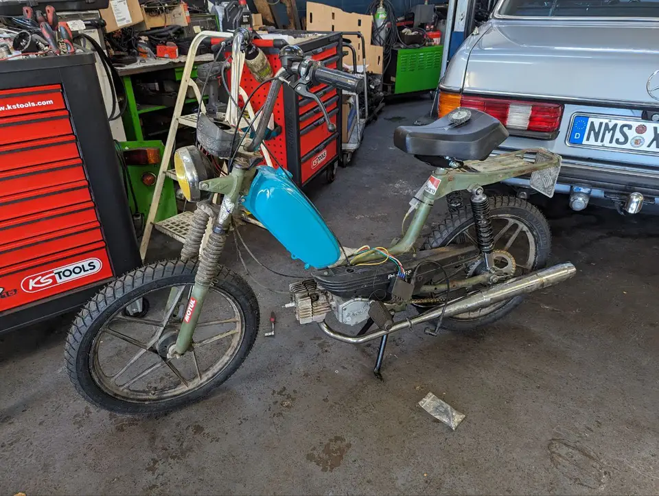 A partially restored Hercules Prima moped in a workshop