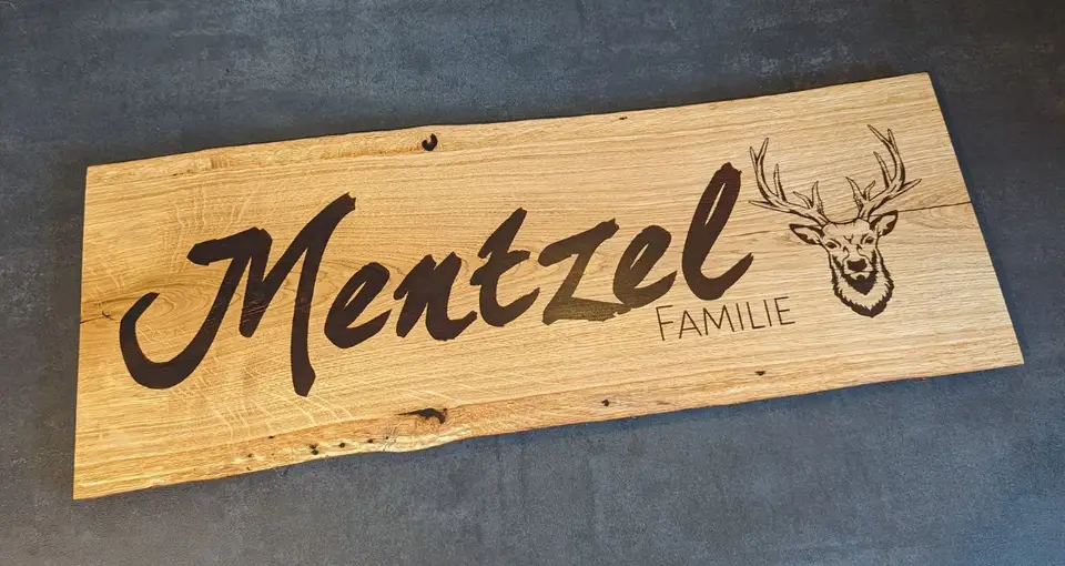 An engraved oak sign reading Mentzel Familie with a deer illustration